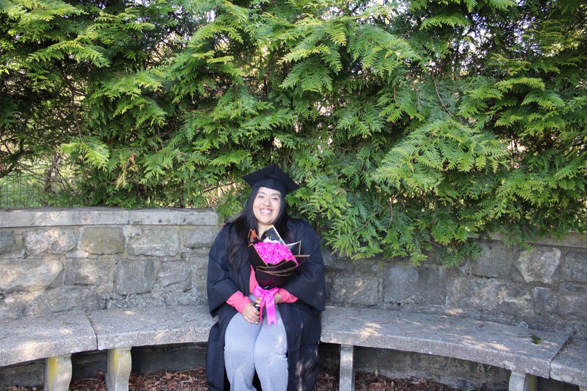 Graduate portrait in front of purple flowers